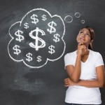 Woman stands thoughfully in front of blackboard with a thougth bubble of dollar signs.