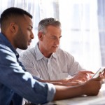 Younger and older man look at papers