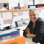 Gray haired smiling woman at desk