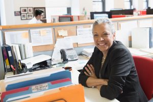Gray haired smiling woman at desk