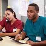 Male and female nurses at desk