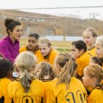 Female coach with girls soccer team