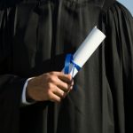 Male graduate holding diploma