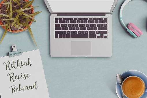 office desktop with revise rebrand and the rethink text on clipboard