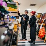 Undertaker showing coffins to a widow