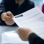 person handing resume to interviewer